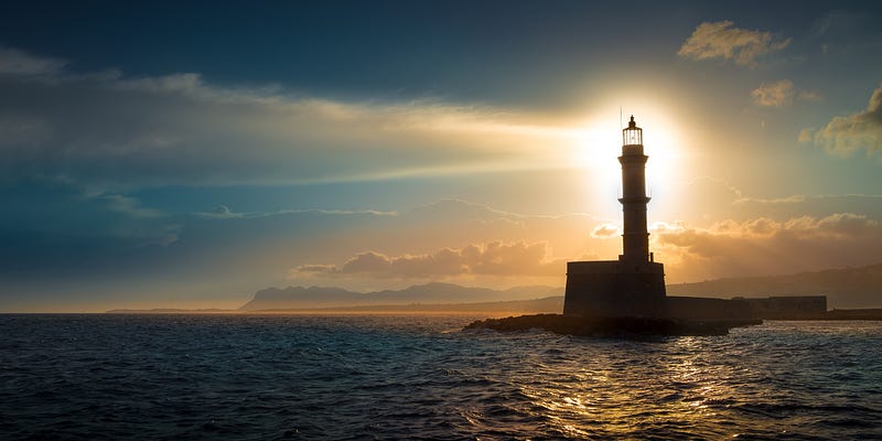 A beautiful night sky behind a shining lighthouse.